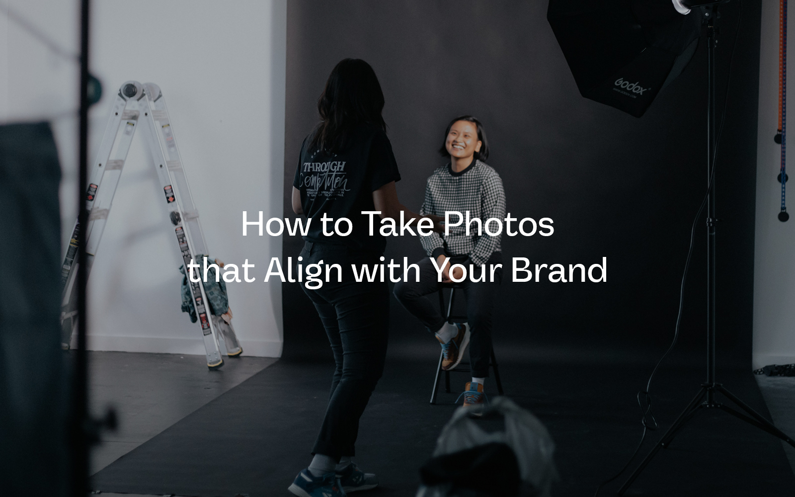 Two women on set in a photo studio working on brand photos for their small business.