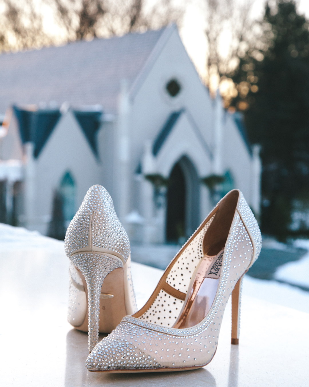Pair of elegant heels positioned in front of a church.