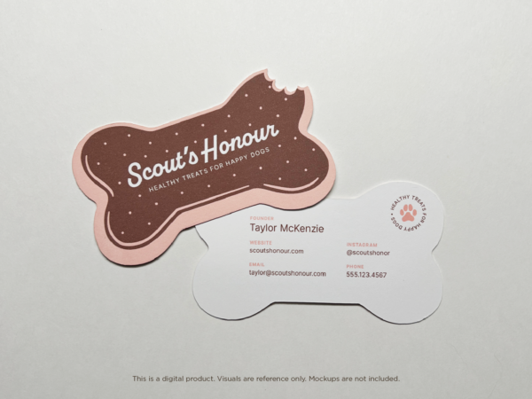 A full view of both the front and back sides of a dog bone-shaped business card for a dog bakery business. The front features the brand name in white on a brown background with a pink border, while the back includes contact information on a white background. Both sides maintain the playful bite-mark detail.